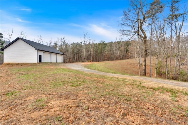 view of yard with an outbuilding and driveway