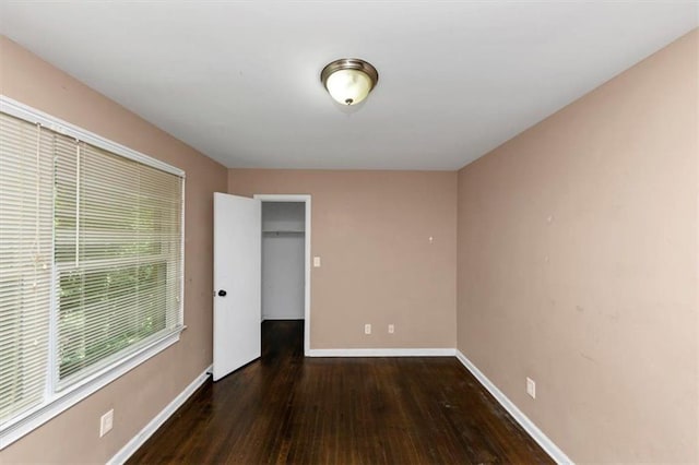 2702 Rollingwood Ln SE, Atlanta, GA 30316 - unfurnished bedroom featuring wood-type flooring, a closet, and a walk in closet