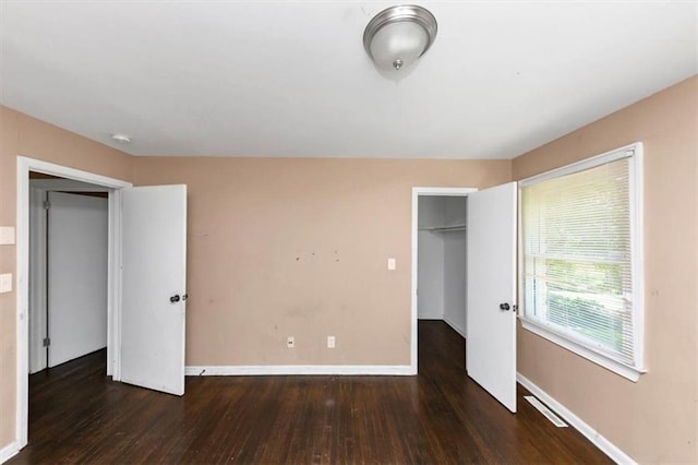 2702 Rollingwood Ln SE, Atlanta, GA 30316 - unfurnished bedroom with wood finished floors, a closet, and a walk in closet