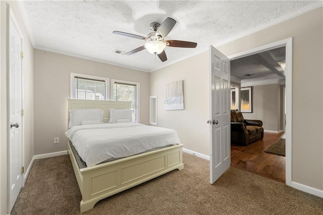 carpeted bedroom featuring ornamental molding, baseboards, ceiling fan, and a textured ceiling