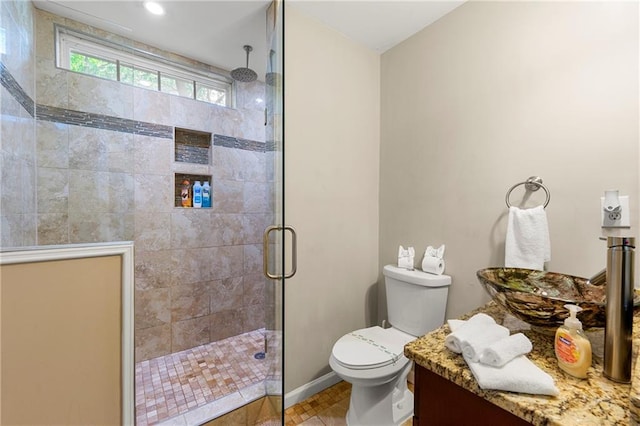 full bath with a tile shower, toilet, and a sink
