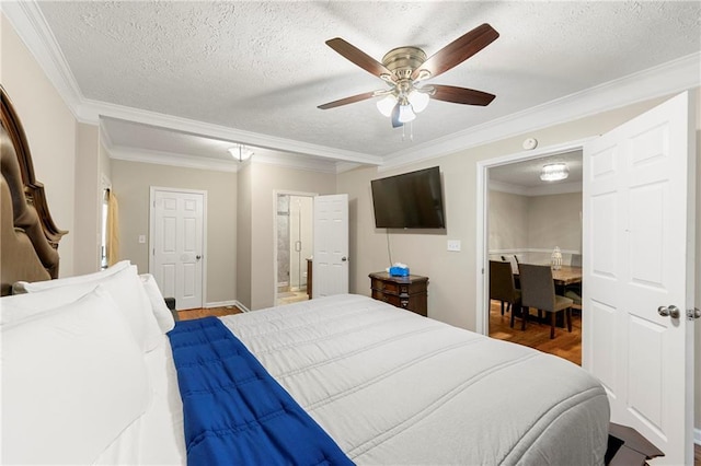 bedroom featuring a textured ceiling, wood finished floors, crown molding, ceiling fan, and ensuite bathroom
