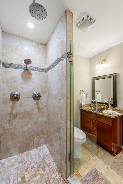 full bathroom featuring a shower stall, vanity, and toilet