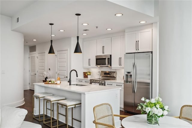 kitchen featuring visible vents, a sink, white cabinetry, stainless steel appliances, and light countertops