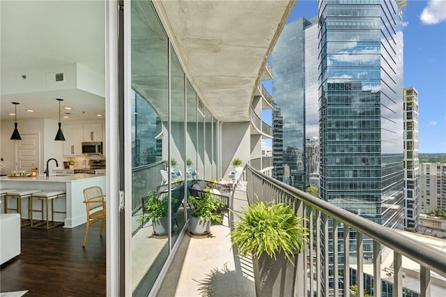 balcony featuring a sink, visible vents, and a city view