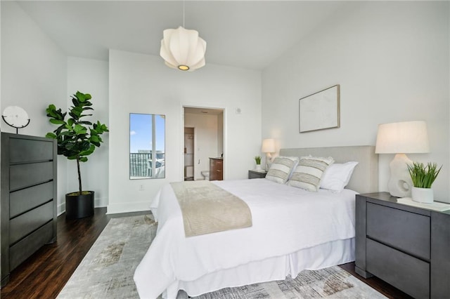 bedroom featuring baseboards, ensuite bath, and dark wood-style floors