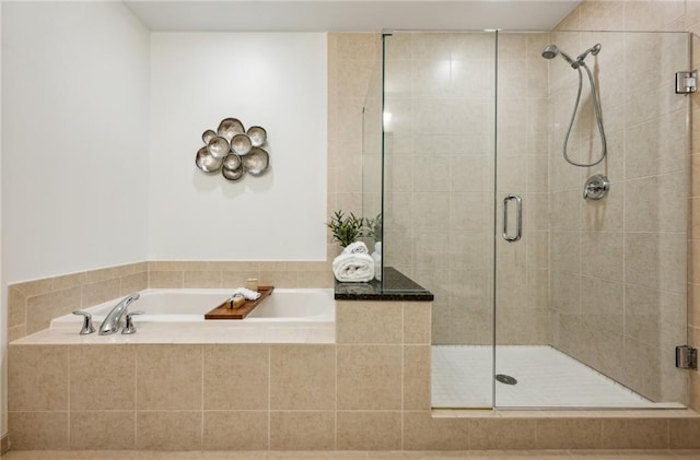 bathroom featuring a stall shower and a bath