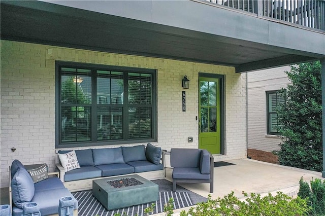 view of patio featuring a balcony and an outdoor living space with a fire pit