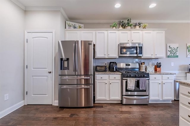 kitchen featuring appliances with stainless steel finishes, white cabinets, light stone countertops, dark hardwood / wood-style flooring, and ornamental molding