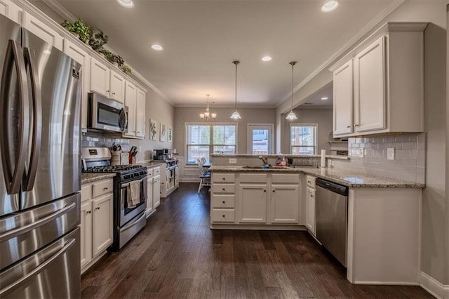 kitchen featuring hanging light fixtures, kitchen peninsula, white cabinetry, appliances with stainless steel finishes, and dark hardwood / wood-style flooring