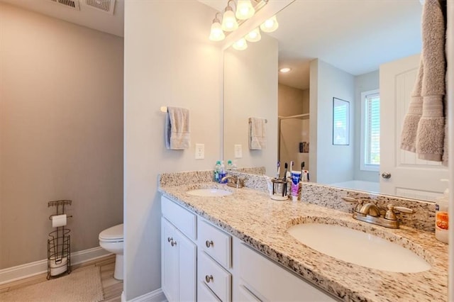 bathroom featuring hardwood / wood-style floors, vanity, toilet, and a shower with door