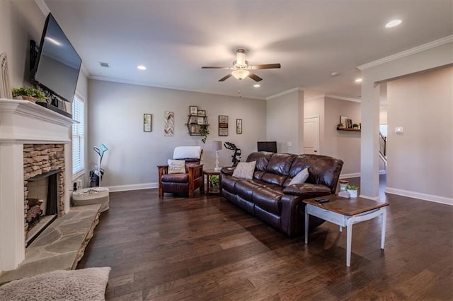 living room featuring ceiling fan, a stone fireplace, dark hardwood / wood-style floors, and crown molding