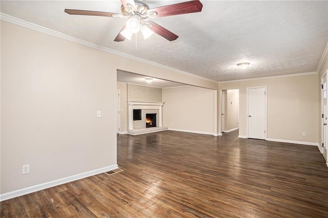 unfurnished living room with ceiling fan, dark hardwood / wood-style flooring, a textured ceiling, a fireplace, and ornamental molding