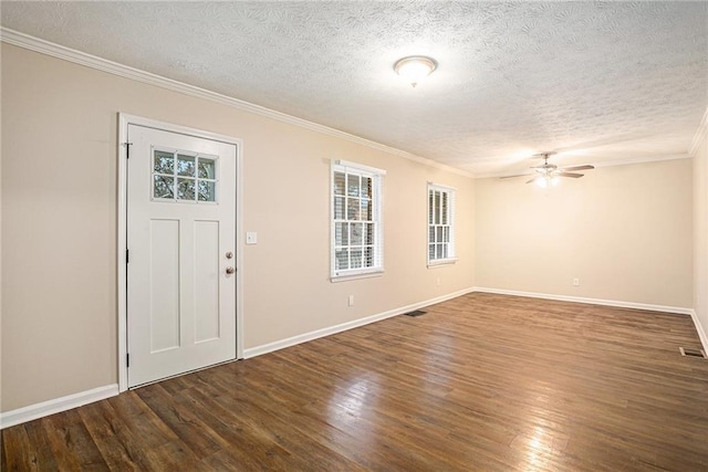 entryway featuring a textured ceiling, ornamental molding, and dark wood-type flooring