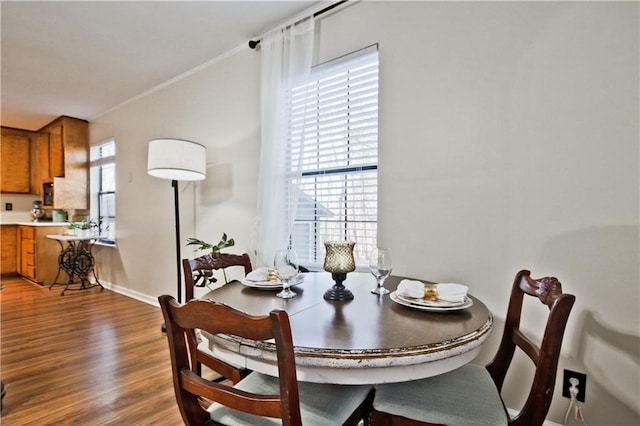 dining room featuring a wealth of natural light, ornamental molding, and hardwood / wood-style floors