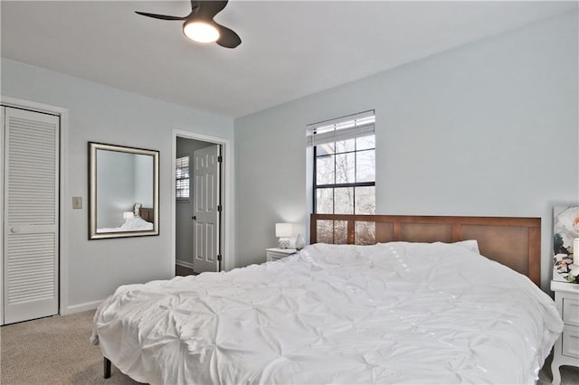 carpeted bedroom with ceiling fan and a closet