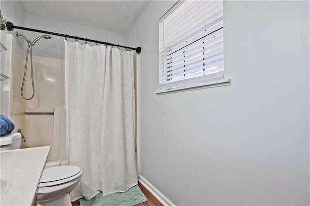 bathroom with toilet, hardwood / wood-style flooring, vanity, and curtained shower