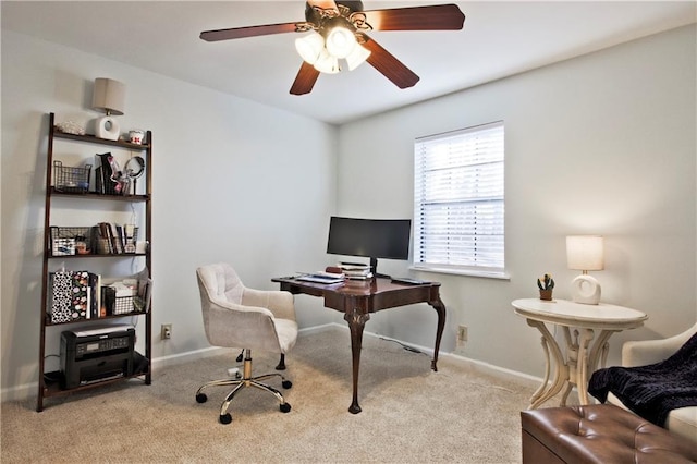 carpeted home office featuring ceiling fan