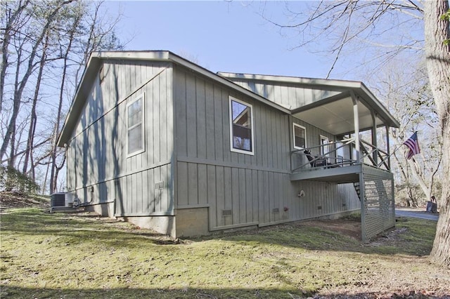 view of side of home featuring central AC unit and a lawn