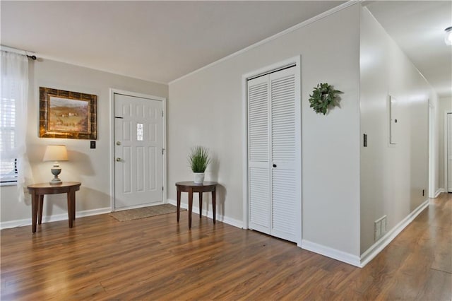 foyer featuring dark hardwood / wood-style floors and crown molding