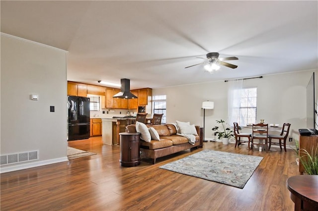 living room featuring ceiling fan, dark hardwood / wood-style floors, and crown molding