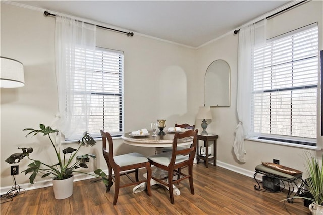 dining space with dark hardwood / wood-style floors and crown molding