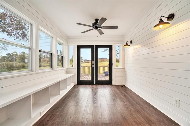 unfurnished sunroom featuring ceiling fan and a healthy amount of sunlight