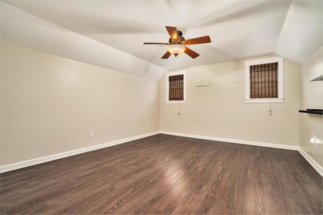 empty room featuring dark hardwood / wood-style flooring, vaulted ceiling, and ceiling fan