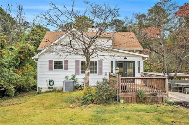 back of property with cooling unit, a wooden deck, and a lawn