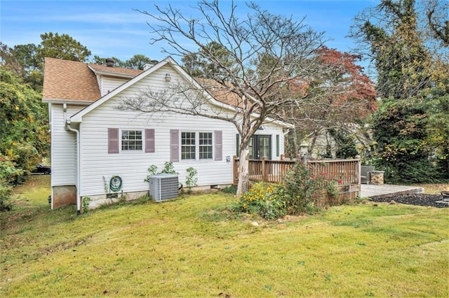 rear view of property featuring a wooden deck, cooling unit, and a lawn