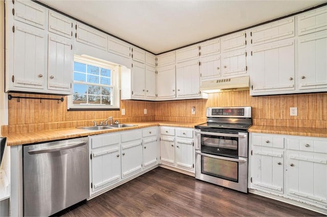 kitchen featuring appliances with stainless steel finishes, sink, dark wood-type flooring, and white cabinets