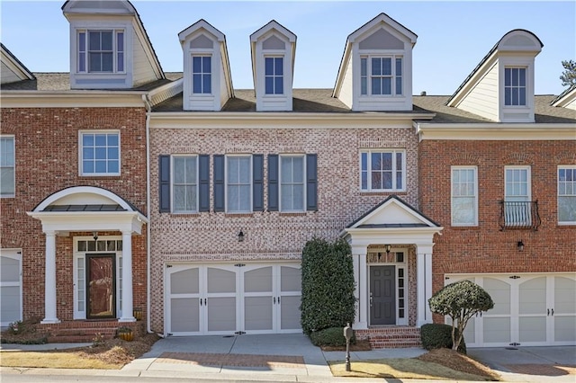 view of front of house with driveway, brick siding, and an attached garage