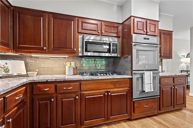 1075 Winding Branch Ln, Atlanta, GA 30338 - kitchen featuring stainless steel appliances, light wood finished floors, decorative backsplash, and light stone counters