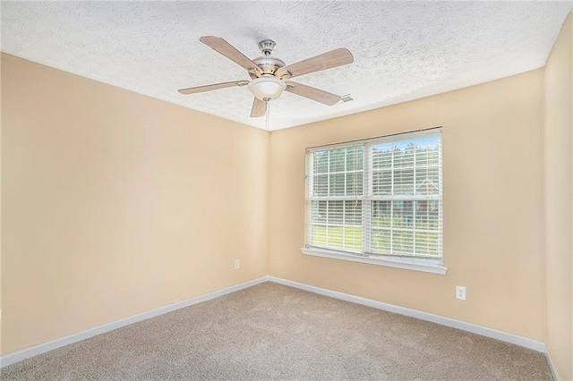 carpeted empty room featuring ceiling fan, baseboards, and a textured ceiling