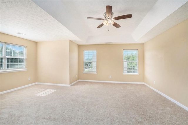 unfurnished room with light carpet, a textured ceiling, and baseboards