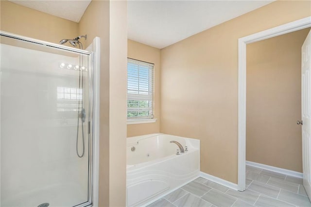 bathroom with tile patterned floors, a shower stall, baseboards, and a bath