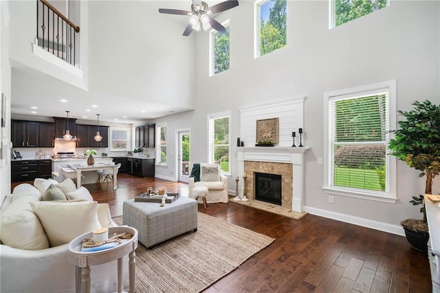 4460 Hunters Walk Way, Cumming, GA 30028 - living area with a towering ceiling, dark wood-style floors, ceiling fan, and a fireplace with flush hearth