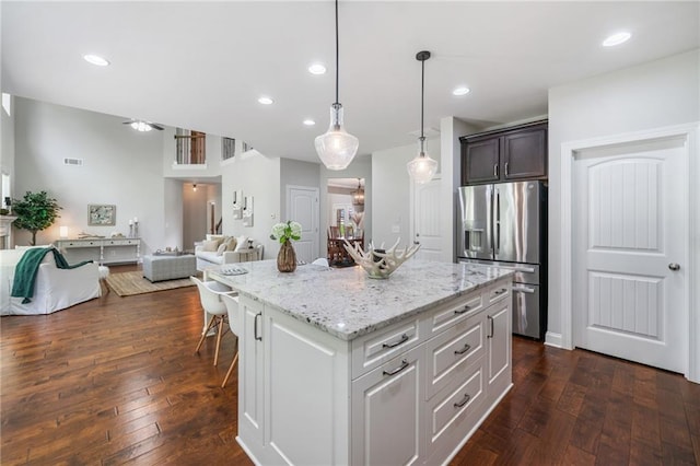 4460 Hunters Walk Way, Cumming, GA 30028 - kitchen featuring stainless steel refrigerator with ice dispenser, open floor plan, light stone counters, dark wood-style flooring, and a kitchen island
