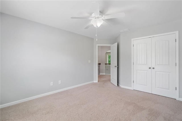 4460 Hunters Walk Way, Cumming, GA 30028 - unfurnished bedroom featuring light carpet, a closet, arched walkways, and a ceiling fan