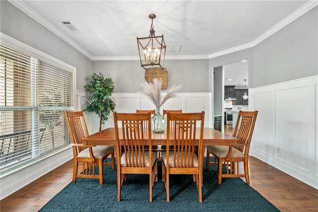 4460 Hunters Walk Way, Cumming, GA 30028 - dining area featuring a chandelier, a decorative wall, ornamental molding, wood finished floors, and wainscoting