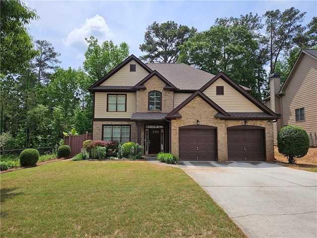 craftsman-style home with an attached garage, fence, a front yard, brick siding, and driveway