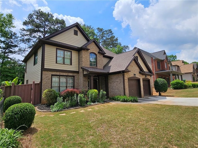 craftsman-style house with fence, concrete driveway, brick siding, and a front yard