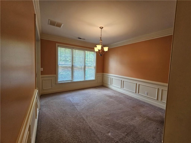 carpeted empty room featuring crown molding, visible vents, a wainscoted wall, and an inviting chandelier