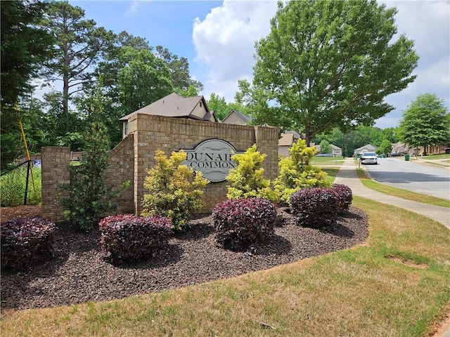 community / neighborhood sign featuring a yard