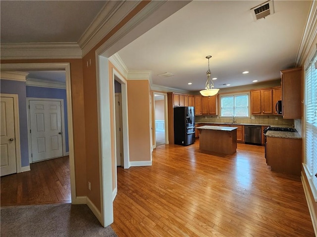 kitchen with a center island, a sink, stainless steel appliances, baseboards, and light wood-style floors