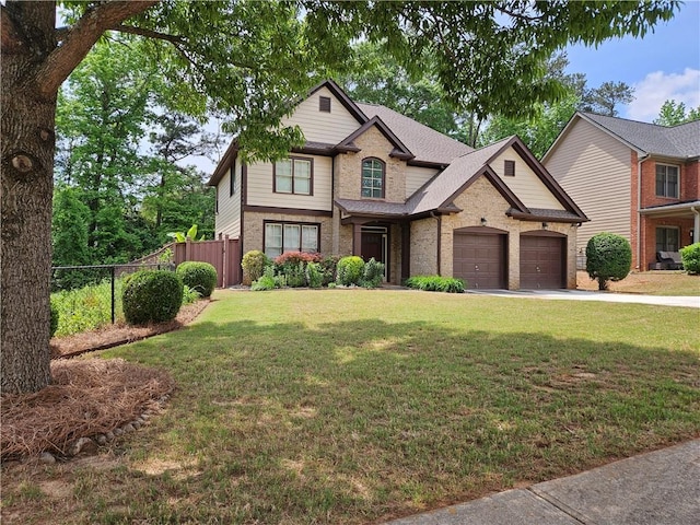 view of front facade featuring brick siding, fence, a garage, concrete driveway, and a front yard