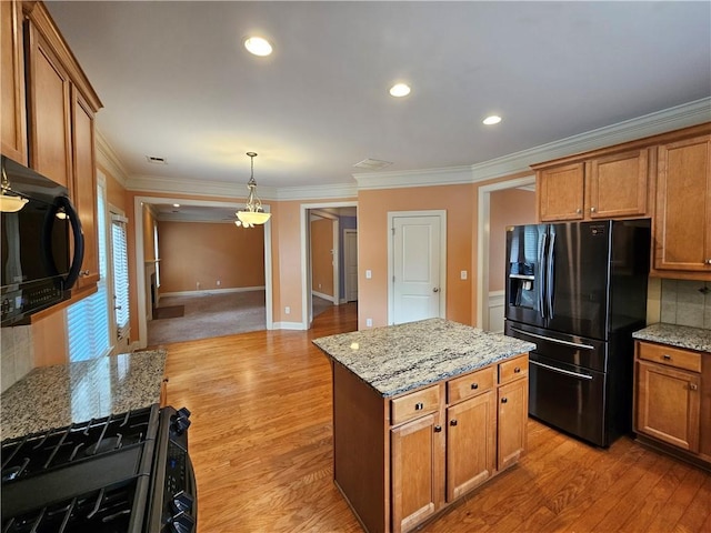 kitchen with light wood-style flooring, brown cabinetry, ornamental molding, backsplash, and black appliances