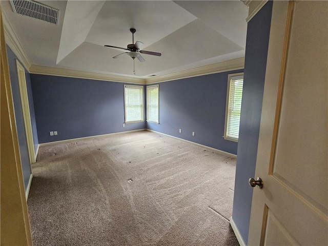 spare room with visible vents, crown molding, ceiling fan, carpet flooring, and a raised ceiling