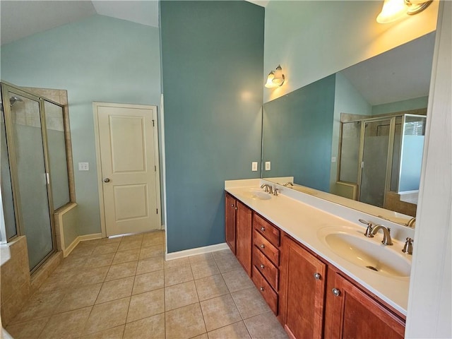 bathroom with a sink, high vaulted ceiling, tile patterned floors, a shower stall, and double vanity