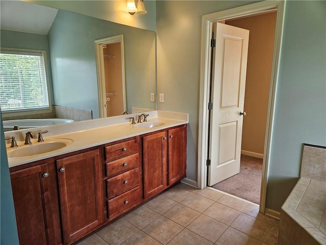 full bathroom featuring a sink, double vanity, a bath, and tile patterned floors